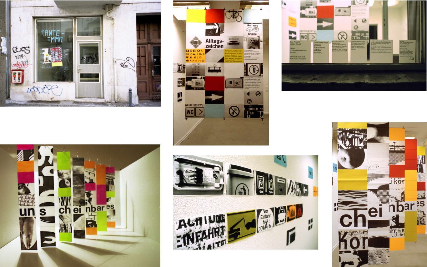 Fensteransicht mit Ausstellung, Wände mit bunten Grafiken und Fotos gestaltet.