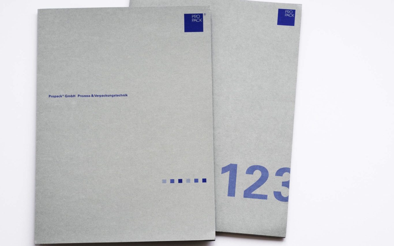 Graue Broschüren mit blauen Schriftzügen, eine mit "123" und die andere mit Titel.