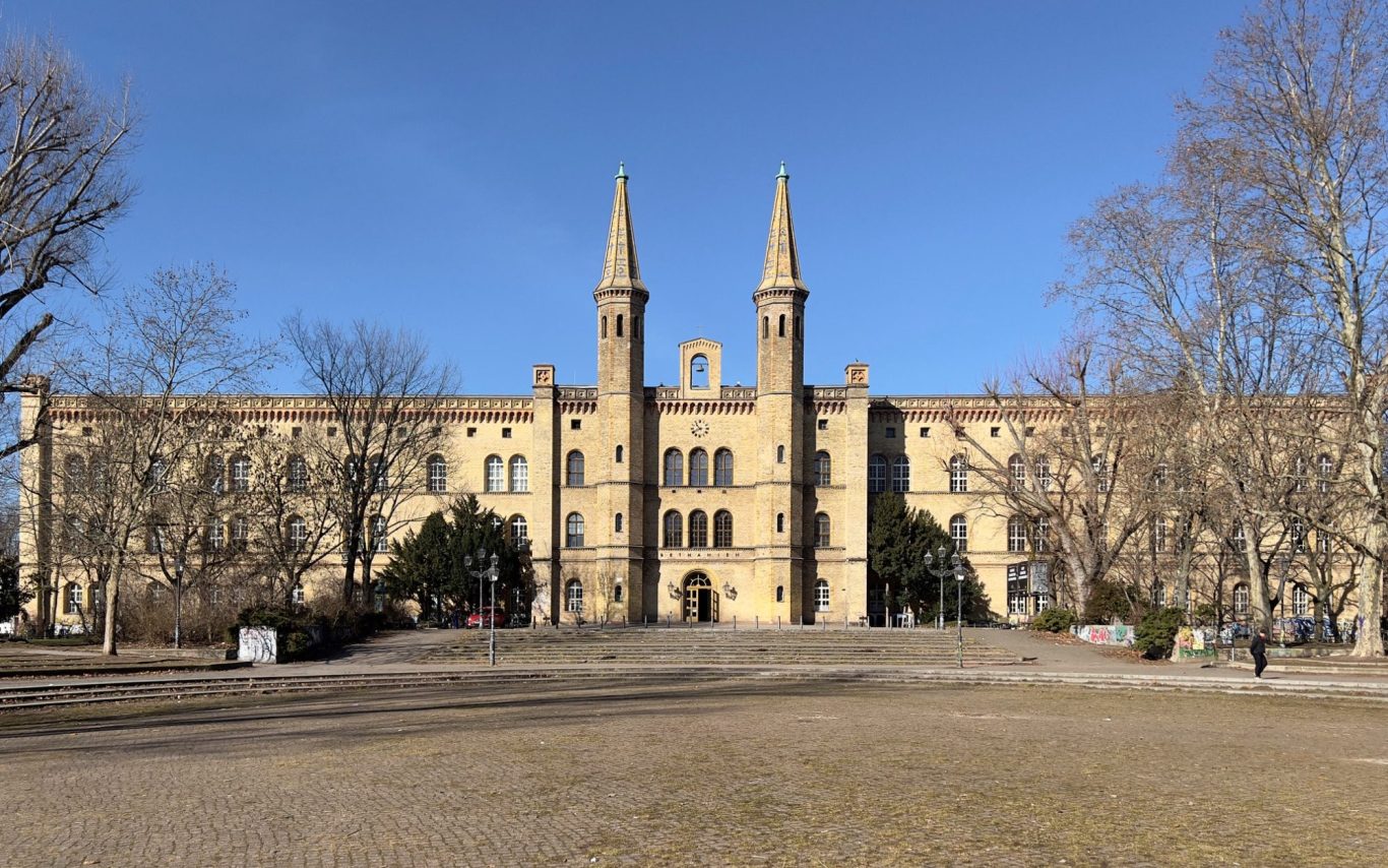 Historisches Gebäude mit zwei Türmen und einem blauen Himmel im Hintergrund.