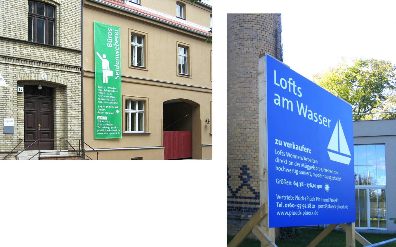 Grüne Bannerwerbung an einem Gebäude, daneben ein blaues Schild am Wasser.