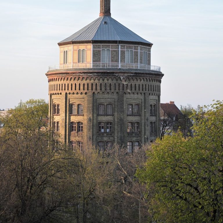 Wasserturm umgeben von grünen Bäumen.