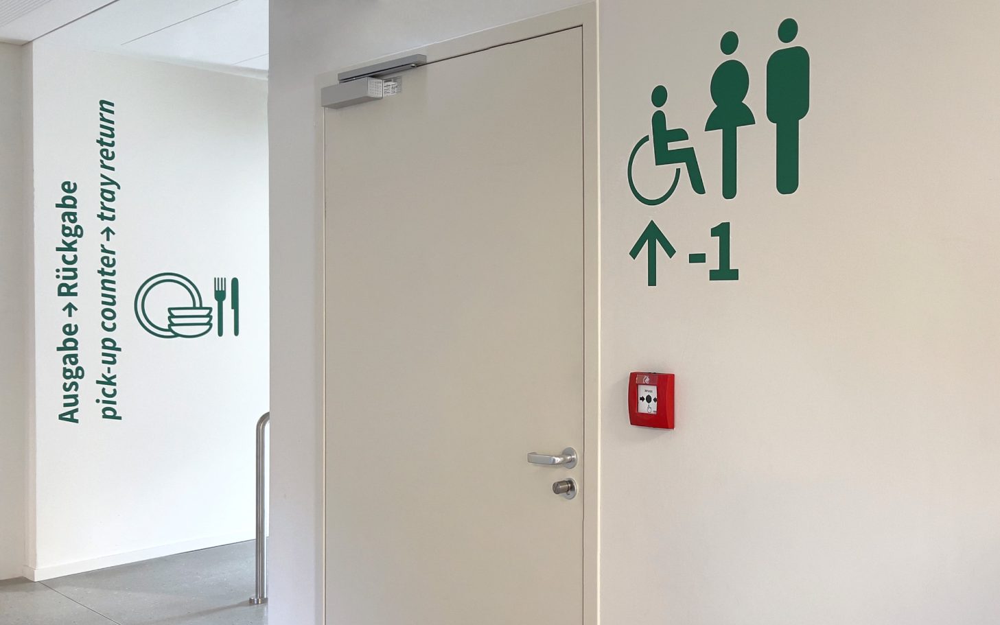 Wand mit Symbolen für barrierefreie Toilette und Stockwerk -1.
