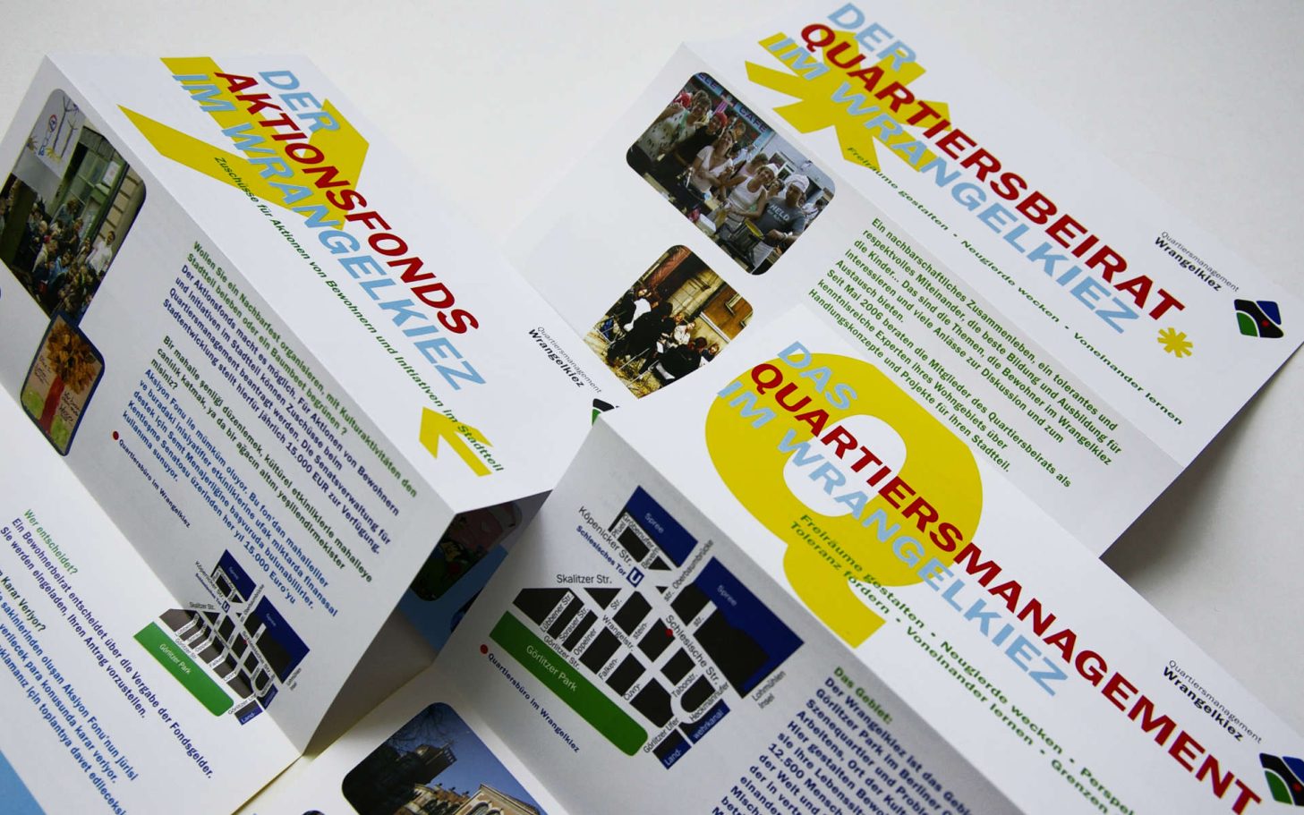 Drei gefaltete Informationsbroschüren mit bunten Überschriften und Bildern.