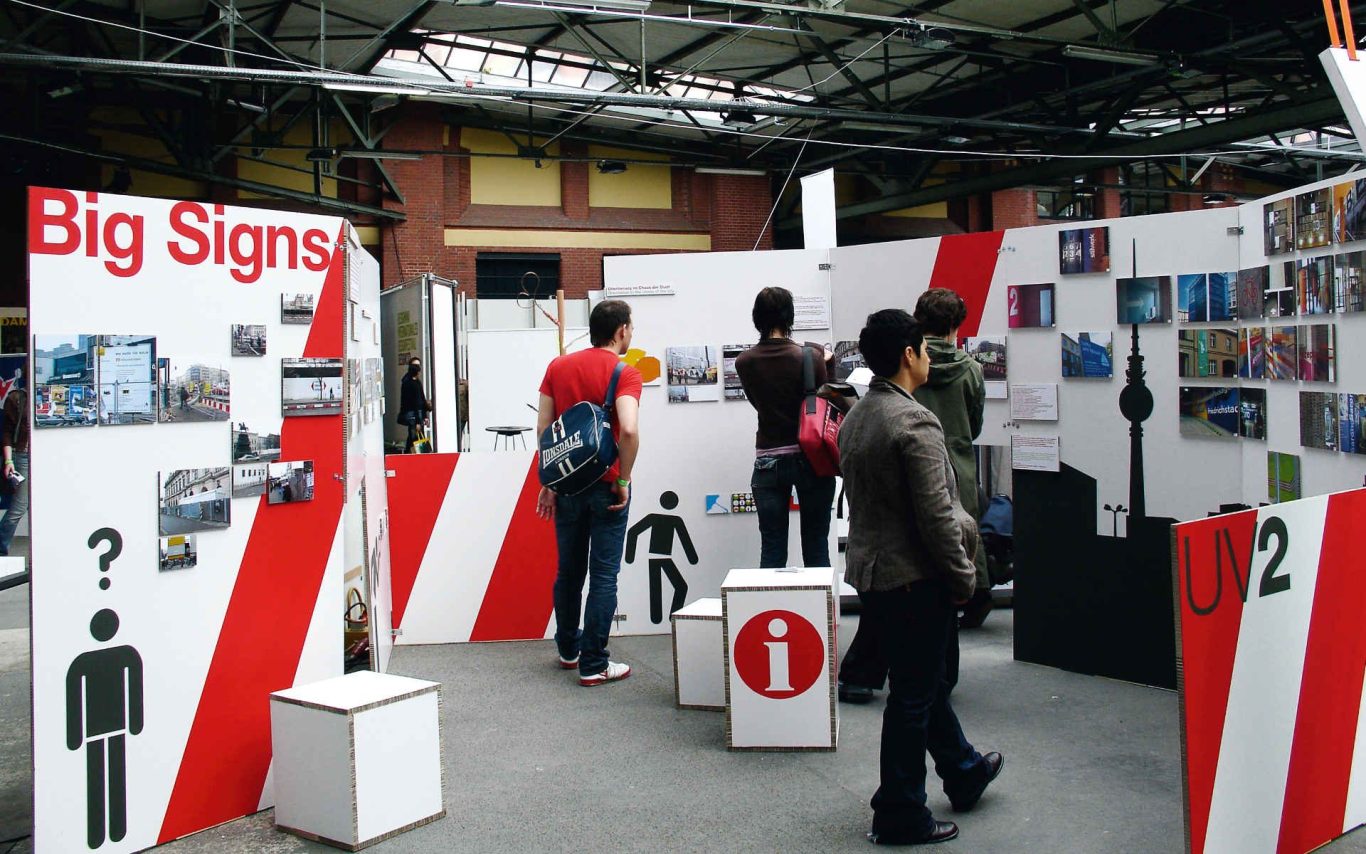 Besucher erkunden unsere Ausstellung mit Informationswänden und Bildern.
