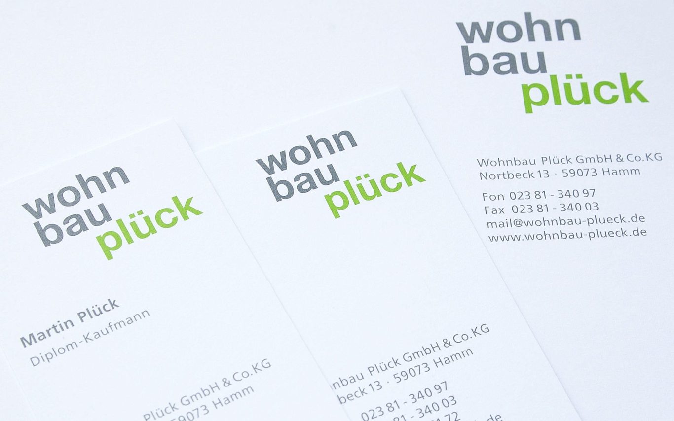 Visitenkarten mit dem Schriftzug "wohnbau plück" in modernem Design.